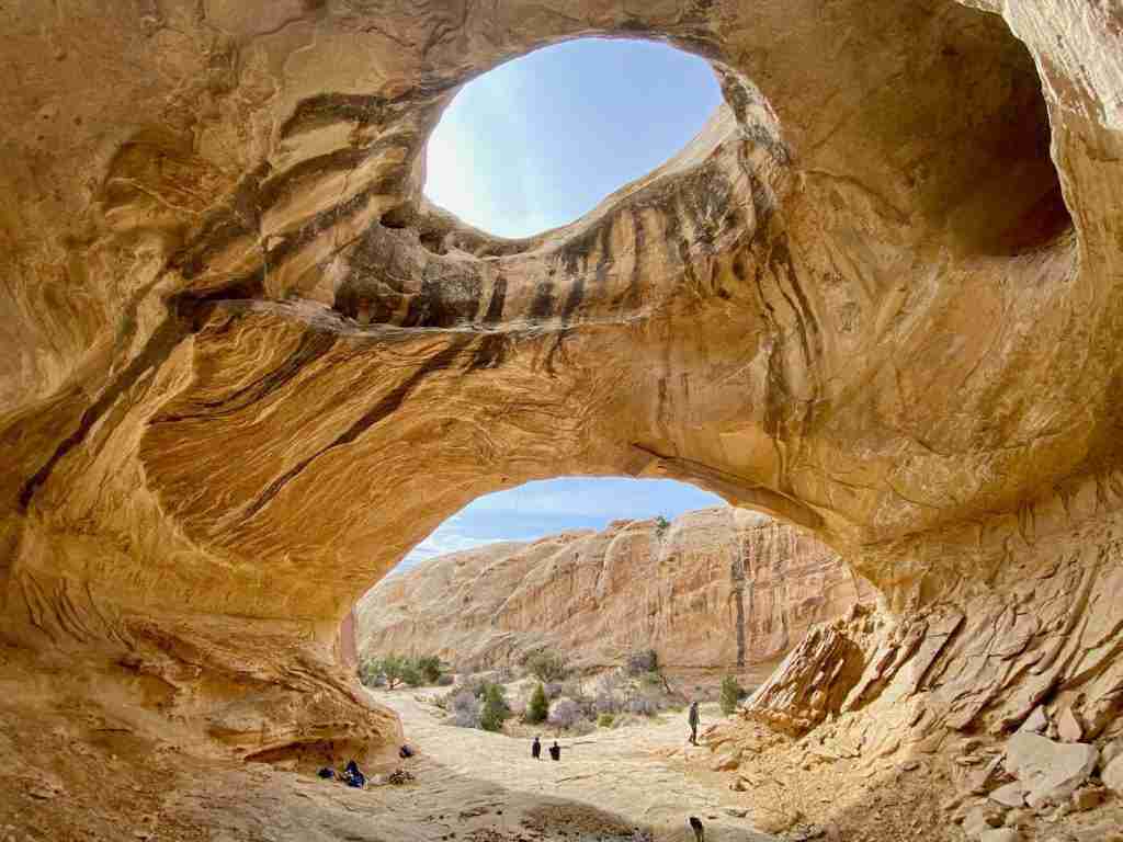 Large rock dome structure with a hole at the top called Wild Horse Window outside of Goblin Valley State Park in Utah